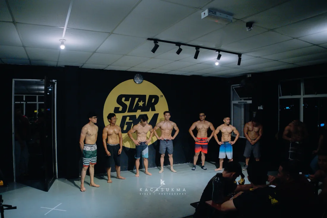 Line of athletes posing together on stage at a Star Gym competition