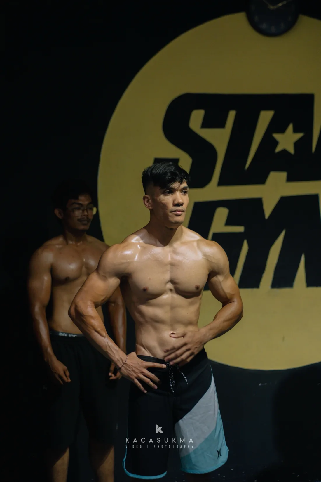 Competitor performing a front double biceps pose on stage